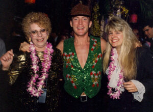 A group of partygoers at a Christmas Party wearing sequin vests and leis